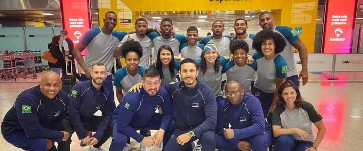 Delegação brasileira posa para foto na área de embarque