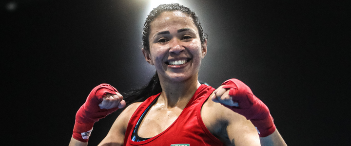 Carol Naka posa para foto sorrindo e com os dois punhos erguidos